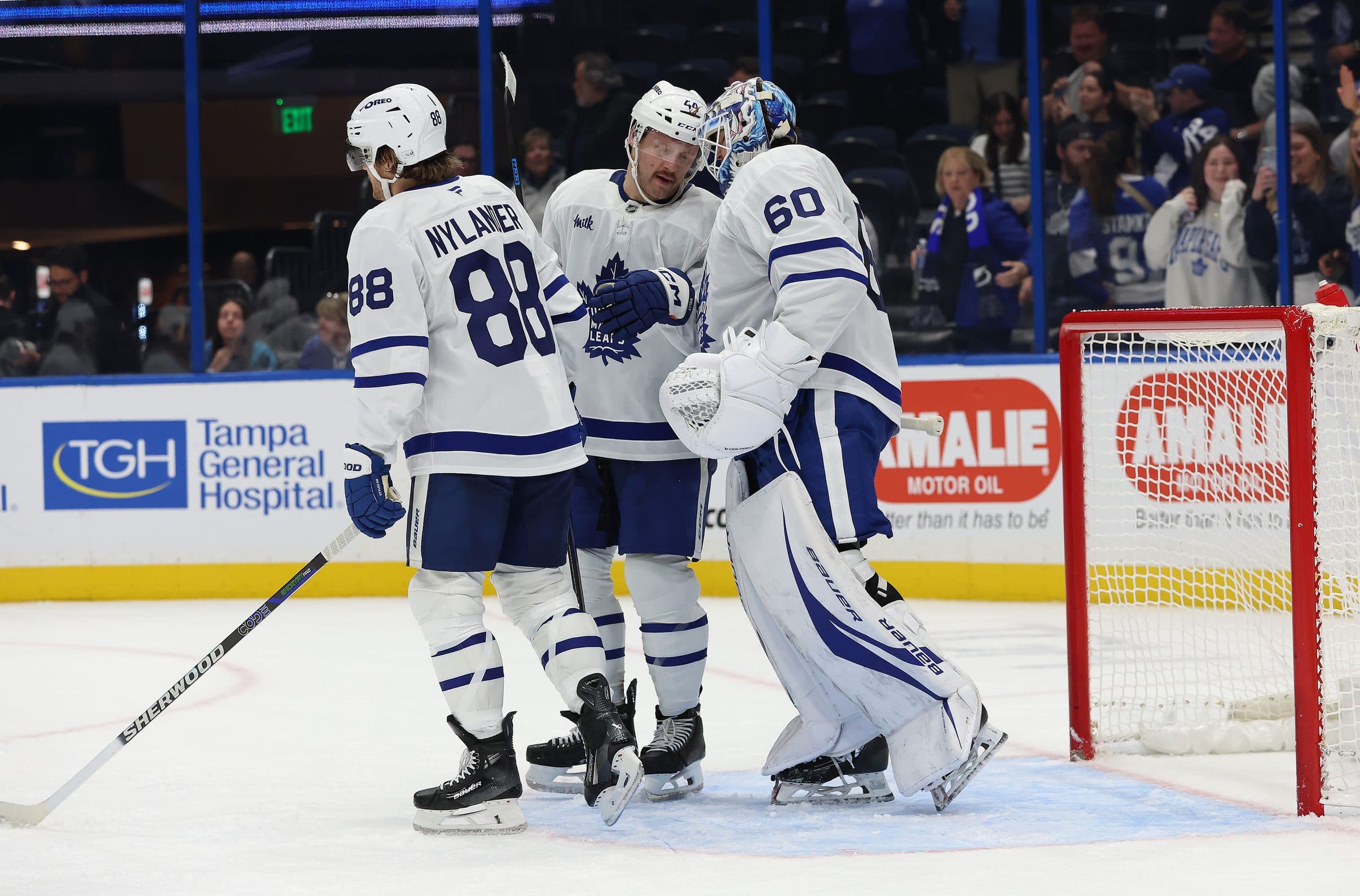 Toronto Maple Leafs defenseman Morgan Rielly (44), goaltender Joseph Woll (60) and right wing William Nylander (88) celebrate after they beat the Tampa Bay Lightning at Amalie Arena.