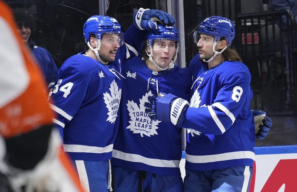 Toronto Maple Leafs forward Auston Matthews (34) and defenceman Chris Tanev (8) congratulate forward Matthew Knies (23) after his goal against the Philadelphia Flyers during the first period at Scotiabank Arena.