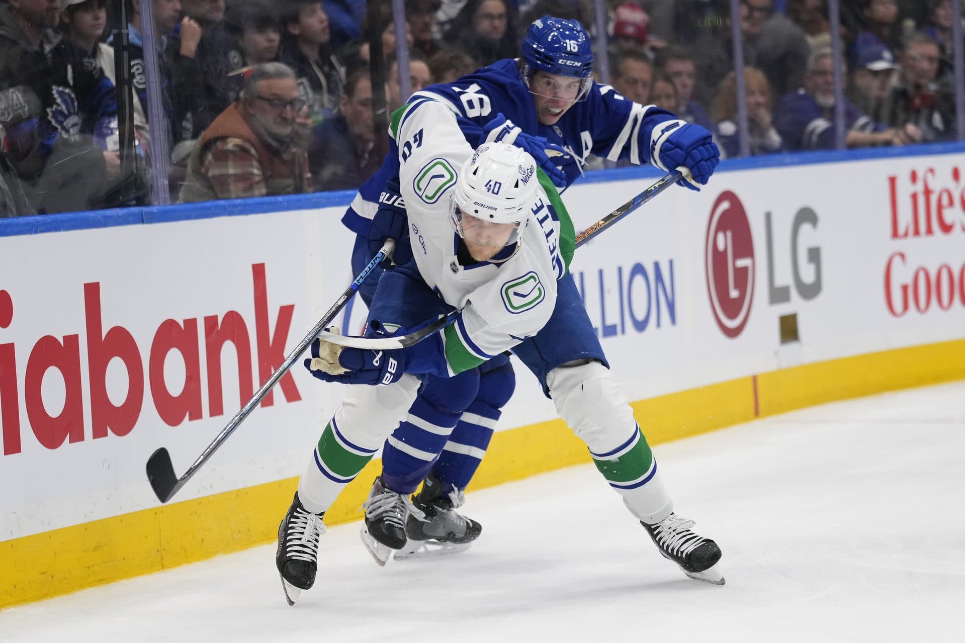 Toronto Maple Leafs forward Mitch Marner (16) tries to slow up Vancouver Canucks forward Elias Pettersson (40) during the third period at Scotiabank Arena.